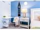 Charming bedroom with a whimsical Big Ben wall decal, a stylish nightstand, and a cozy chair at 665 Longboat Dr, Davenport, FL 33896