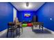 Vibrant game room with bright blue walls, foosball, a connect four game, seating, and entertainment features at 665 Longboat Dr, Davenport, FL 33896