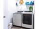 Functional laundry room with modern washer and dryer units, a wire shelf with storage, and a clean white interior at 665 Longboat Dr, Davenport, FL 33896