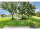 This backyard features a well-maintained lawn, mature trees, a tranquil lake view, and lovely landscaping at 685 Middlebury Loop, New Smyrna Beach, FL 32168