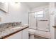 This bathroom features a granite countertop, framed mirror, and a tub with a sliding glass door at 685 Middlebury Loop, New Smyrna Beach, FL 32168