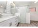 Updated bathroom with double sinks, glass shower enclosure, marble countertops, and plank accent wall at 685 Middlebury Loop, New Smyrna Beach, FL 32168