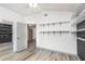 This bedroom features wood-look floors, built-in shelving, neutral paint, and an open door to the hallway at 685 Middlebury Loop, New Smyrna Beach, FL 32168