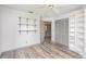This bedroom features wood-look floors, built-in shelving, neutral paint, and a gray closet at 685 Middlebury Loop, New Smyrna Beach, FL 32168