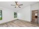 Airy bedroom featuring wood-look floors, a large window, and access to ensuite at 685 Middlebury Loop, New Smyrna Beach, FL 32168