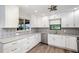 Well-lit kitchen featuring white cabinetry, stainless steel appliances, and modern backsplash at 685 Middlebury Loop, New Smyrna Beach, FL 32168