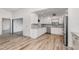 Bright, modern kitchen with white cabinetry, stainless steel appliances, and wood-look tile flooring at 685 Middlebury Loop, New Smyrna Beach, FL 32168