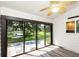 Bright sunroom with wood-look floors and large sliding glass doors overlooking a serene lake at 685 Middlebury Loop, New Smyrna Beach, FL 32168