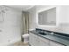 Bathroom featuring a walk-in shower, vanity with a gray marble top and mirror, providing a functional design at 6906 Sawmill Blvd, Ocoee, FL 34761