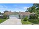Inviting one-story home with well-manicured lawn and beautiful landscaping, plus a spacious driveway at 6906 Sawmill Blvd, Ocoee, FL 34761