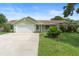 Charming one-story home with well-maintained lawn and a two car garage on a bright day at 6906 Sawmill Blvd, Ocoee, FL 34761