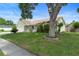 Inviting one-story home surrounded by lush landscaping and mature trees on a sunny day at 6906 Sawmill Blvd, Ocoee, FL 34761
