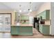 Open concept kitchen with green cabinetry, stainless steel appliances, and granite counters, promoting a modern cooking experience at 6906 Sawmill Blvd, Ocoee, FL 34761