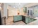 An updated kitchen with green cabinets, granite countertops, and stainless-steel appliances offering a blend of style and functionality at 6906 Sawmill Blvd, Ocoee, FL 34761