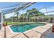 Backyard pool area featuring a screened-in enclosure and a brick-paved deck at 6906 Sawmill Blvd, Ocoee, FL 34761