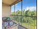 Enjoy the view of lush greenery on the private screened-in balcony with seating area at 8020 Tuscany Way # 6307, Davenport, FL 33896