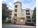 Multi-story condo building with stone facade, balconies and lush surrounding trees at 8020 Tuscany Way # 6307, Davenport, FL 33896