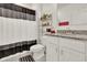 Cozy bathroom showcasing modern fixtures, granite countertops, and a stylish black and white shower curtain at 804 Glen Creek Ct, Fruitland Park, FL 34731