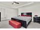 Spacious bedroom with red bench at foot of bed and a black dresser adding storage at 804 Glen Creek Ct, Fruitland Park, FL 34731