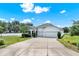 Inviting home featuring a manicured lawn, mature trees, and a spacious two-car garage offers curb appeal at 804 Glen Creek Ct, Fruitland Park, FL 34731