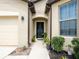 Close-up of front entrance featuring decorative wreath on the door and manicured landscaping at 8710 Rindge Rd, Polk City, FL 33868