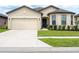 Charming single-story home with a two-car garage, manicured lawn, and decorative front door wreath at 8710 Rindge Rd, Polk City, FL 33868