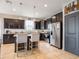 Modern kitchen with stainless steel appliances, dark cabinetry, granite countertops, and breakfast bar seating at 8710 Rindge Rd, Polk City, FL 33868