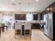 Spacious kitchen featuring dark cabinets, a large island, stainless appliances, and bright lighting at 8710 Rindge Rd, Polk City, FL 33868