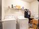 White laundry room with washer, dryer, shelving and tiled floors at 8710 Rindge Rd, Polk City, FL 33868