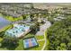 An aerial view of a community featuring a pool, lake, tennis courts, and pickleball courts at 8920 Palisades Beach Ave, Orlando, FL 32829