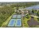 An aerial view of tennis courts, a pool, and a lake within a lush green community at 8920 Palisades Beach Ave, Orlando, FL 32829