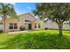 Spacious backyard with green lawn, shade tree, barbecue grill, and privacy fence at 8920 Palisades Beach Ave, Orlando, FL 32829