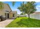 Well maintained backyard with green grass, a paved patio, mature tree, and a white fence at 8920 Palisades Beach Ave, Orlando, FL 32829