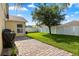 Backyard featuring a paved patio, lush green grass, mature trees, and a white vinyl fence at 8920 Palisades Beach Ave, Orlando, FL 32829