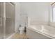 Bathroom featuring a glass shower, a soaking tub, and neutral tiling at 8920 Palisades Beach Ave, Orlando, FL 32829