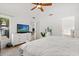 A bright bedroom featuring a flat screen TV, large window, and view into the attached bathroom at 8920 Palisades Beach Ave, Orlando, FL 32829