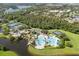 High angle showing community pool, splash pad, tennis courts, and nearby wooded areas at 8920 Palisades Beach Ave, Orlando, FL 32829