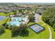 A high-angle shot showcasing community amenities: a pool, splash pad, and tennis court at 8920 Palisades Beach Ave, Orlando, FL 32829