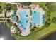 A high-angle shot of community swimming pool, splash pad, umbrellas, lounge chairs, and landscaping at 8920 Palisades Beach Ave, Orlando, FL 32829