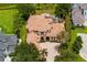 Aerial view showcasing the home's tile roof, screened-in lanai, and spacious brick-paved driveway at 9253 Tibet Pointe Cir, Windermere, FL 34786