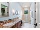 This bathroom features a large vanity with granite countertop, accent mirror, and a walk-in shower at 9253 Tibet Pointe Cir, Windermere, FL 34786