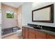 This bathroom includes a vanity with dark countertop, a glass shower with tile and a modern mirror at 9253 Tibet Pointe Cir, Windermere, FL 34786