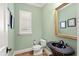 Charming powder room with a pedestal sink, ornate mirror and framed art at 9253 Tibet Pointe Cir, Windermere, FL 34786