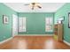 Spacious bedroom with light green walls, hardwood floors, white trim, and two windows at 9253 Tibet Pointe Cir, Windermere, FL 34786