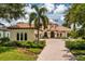 Stunning Mediterranean-style home with a tile roof, lush landscaping, and a circular driveway at 9253 Tibet Pointe Cir, Windermere, FL 34786