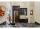 Hallway wet bar with dark cabinets, granite countertop, and wine cooler at 9253 Tibet Pointe Cir, Windermere, FL 34786