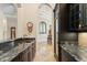 Hallway wet bar with dark cabinets, granite countertop, and a view to dining room at 9253 Tibet Pointe Cir, Windermere, FL 34786