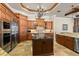 Gourmet kitchen with a large island, custom cabinets, and stainless steel refrigerator at 9253 Tibet Pointe Cir, Windermere, FL 34786