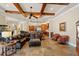 Open-concept living room flowing to the kitchen, showcasing tile floors, wooden beams and a large sofa at 9253 Tibet Pointe Cir, Windermere, FL 34786