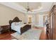 Beautiful bedroom featuring a decorative tray ceiling, a ceiling fan, and a luxurious bed with throw pillows at 9253 Tibet Pointe Cir, Windermere, FL 34786